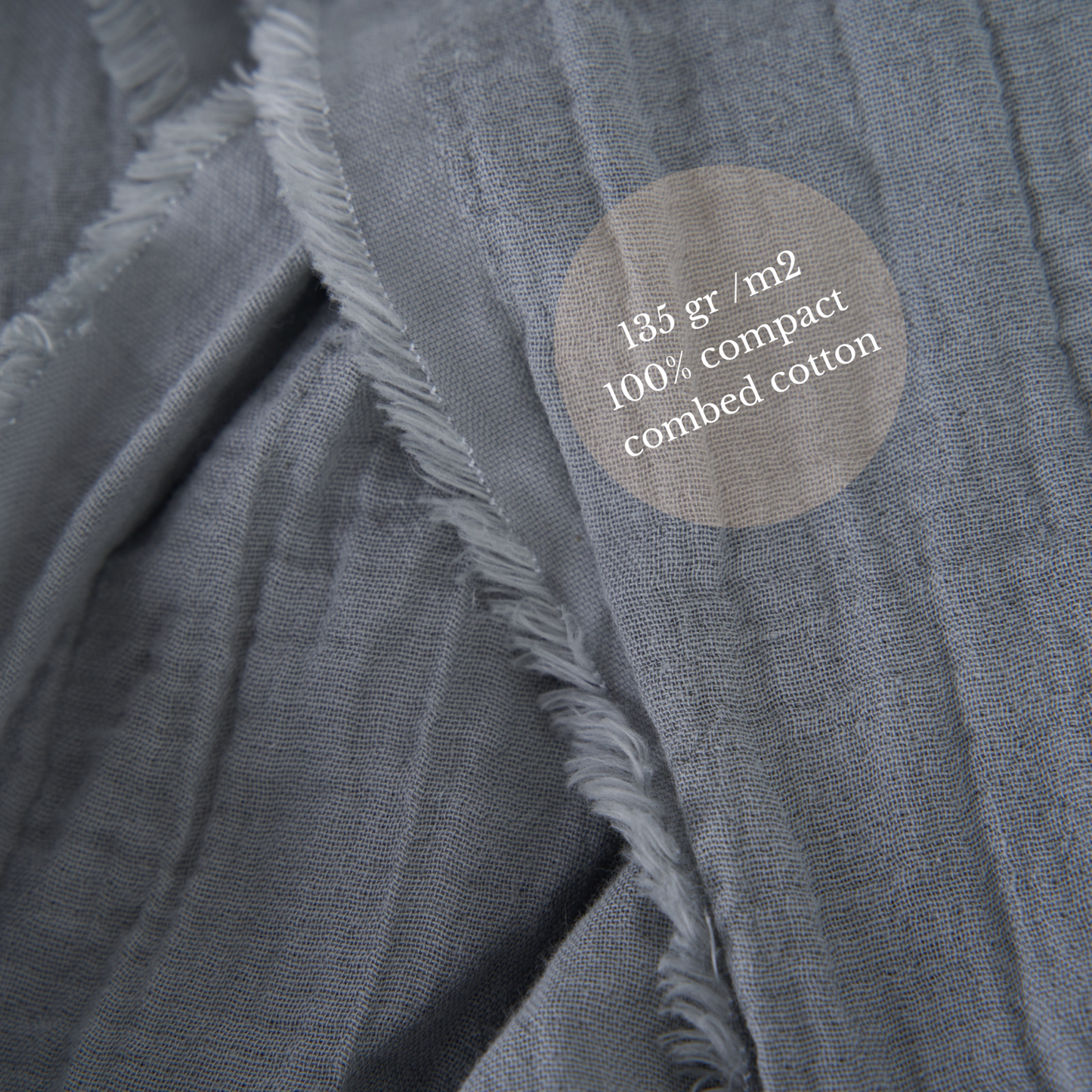 Close-up of grey double-layered crinkled gauze fabric, showcasing texture and softness.