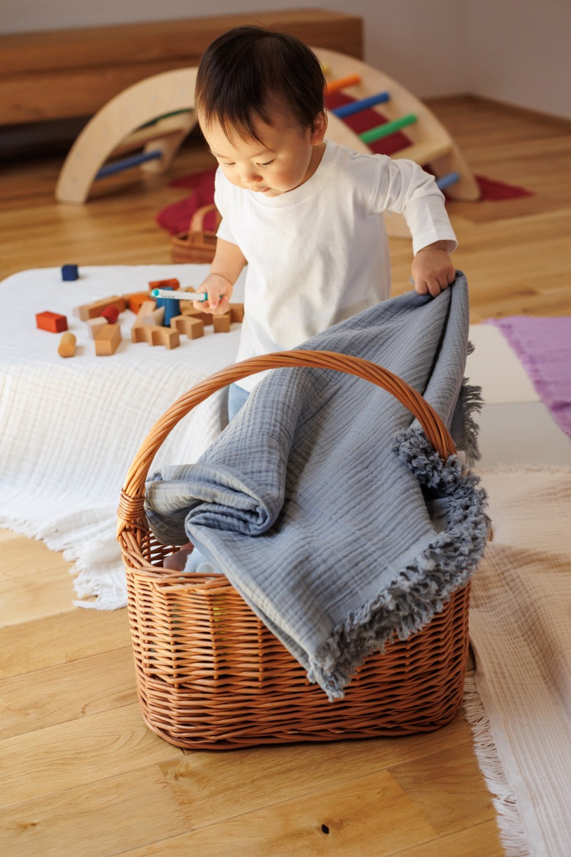 Gray muslin cotton blanket folded, highlighting its soft crinkled texture and natural color.