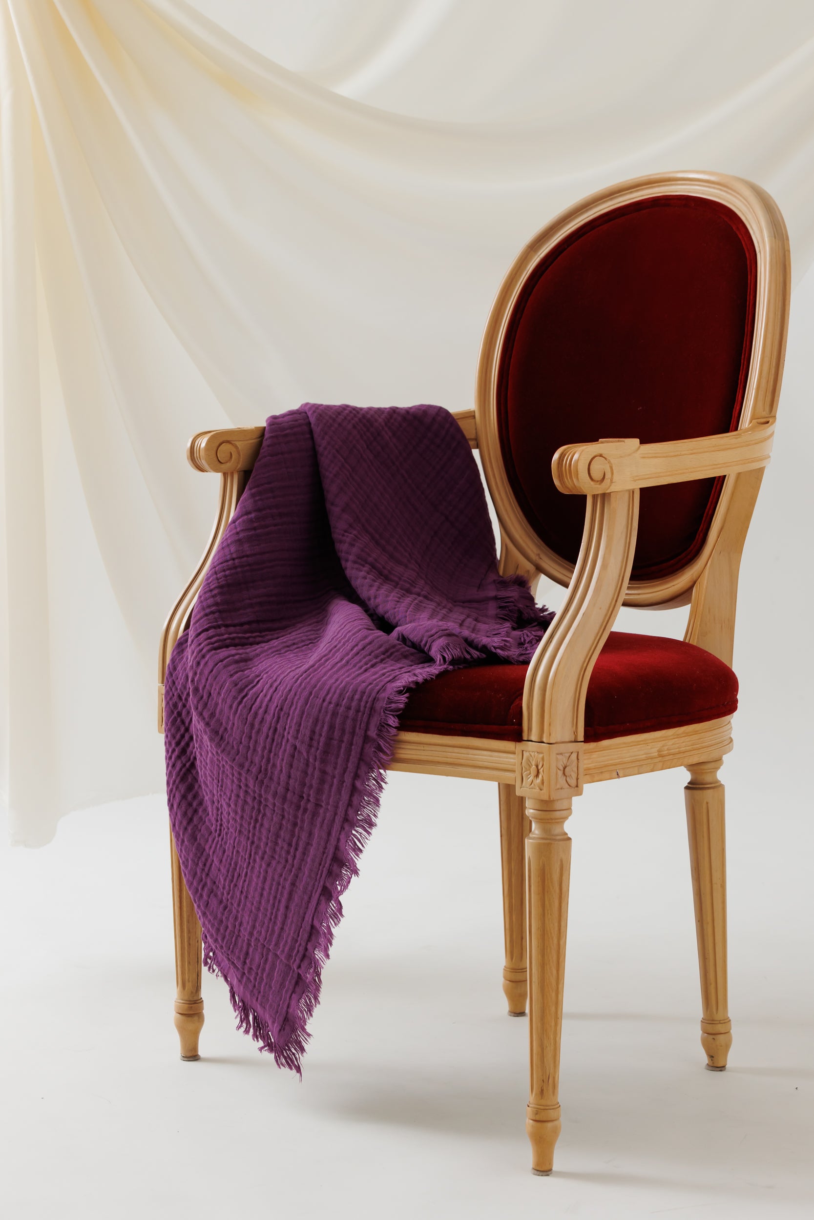 A soft, 4-layer crinkled cotton blanket draped over a chair.