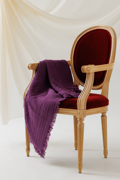 A soft, 4-layer crinkled cotton blanket draped over a chair.